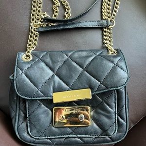 Black padded Michael kors purse with adjustable chain.